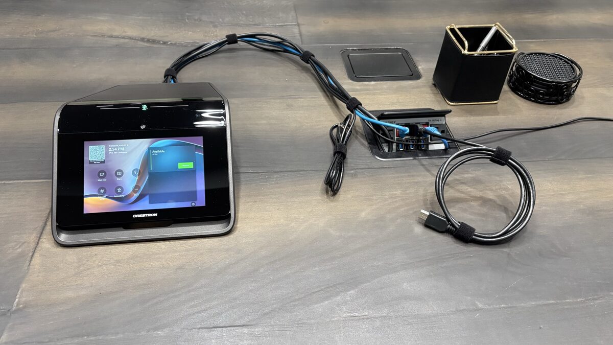 Crestron Flex touch panel on the live-edge conference table next to the table connection box