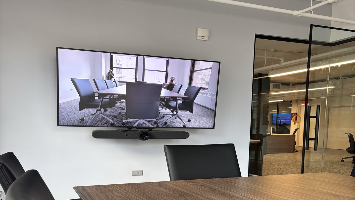 Manhattan 9th floor conference room with a 65-inch display and Logitech Rally Bar installed by Restrepo Innovations