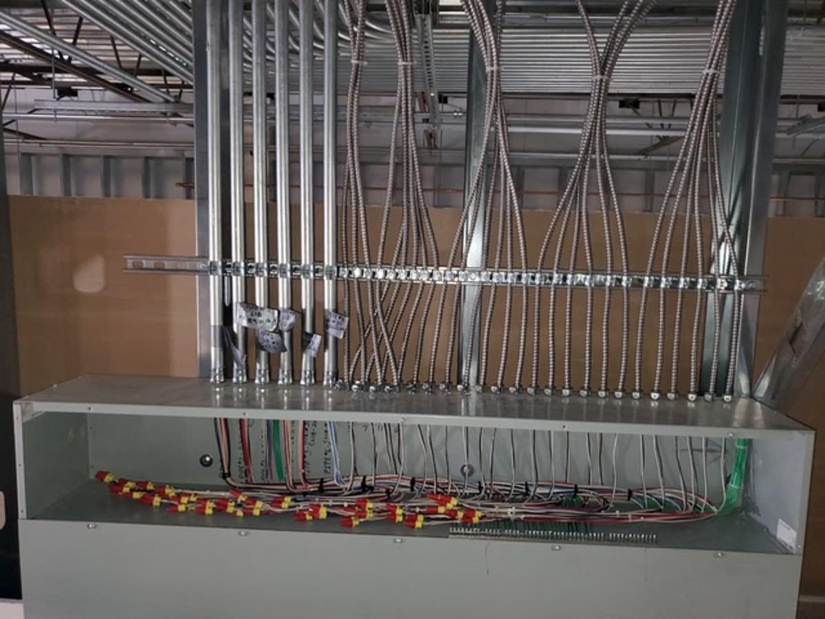 Electrical sub-panel with labeled dedicated circuits and conduit runs installed by Elite Electrical Contracting
