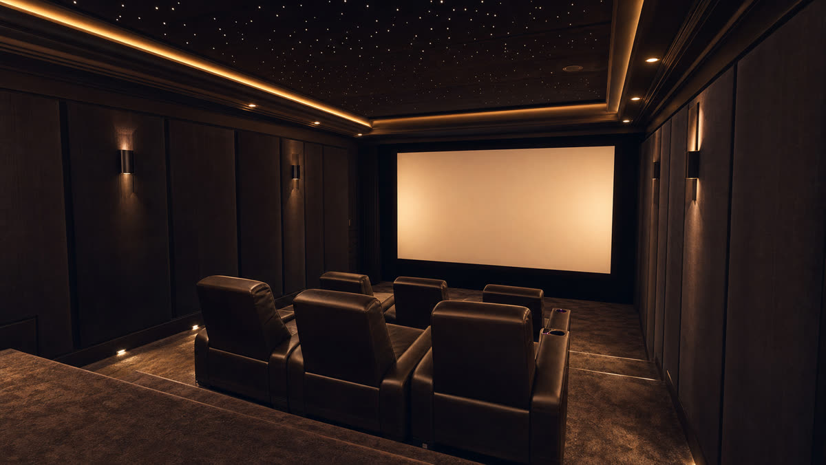 Dedicated home theater with tiered leather seating, acoustic wall panels, and a projection screen in a Franklin Lakes NJ lower level